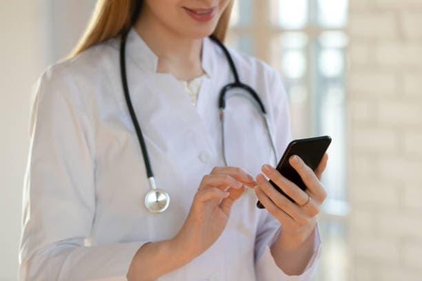 Doctor with phone reviewing patient health data